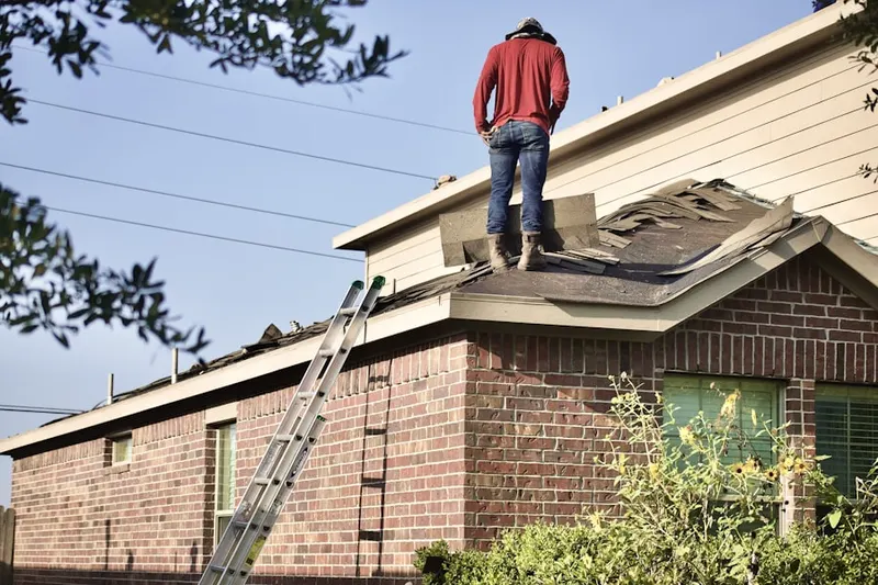 Professional roofer working on a residential roof in Bridlemile